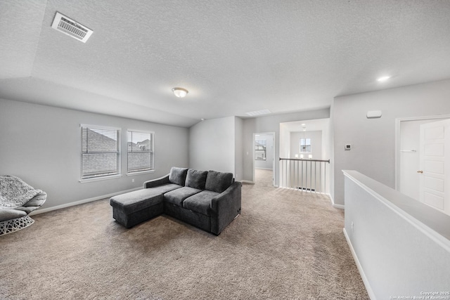 carpeted living room featuring a textured ceiling