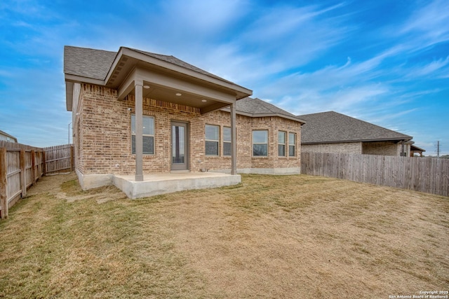 back of house with a yard and a patio