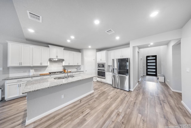 kitchen featuring white cabinetry, light stone counters, and appliances with stainless steel finishes