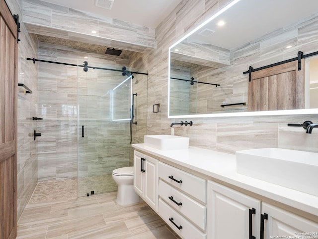 bathroom with tile walls, an enclosed shower, vanity, and toilet