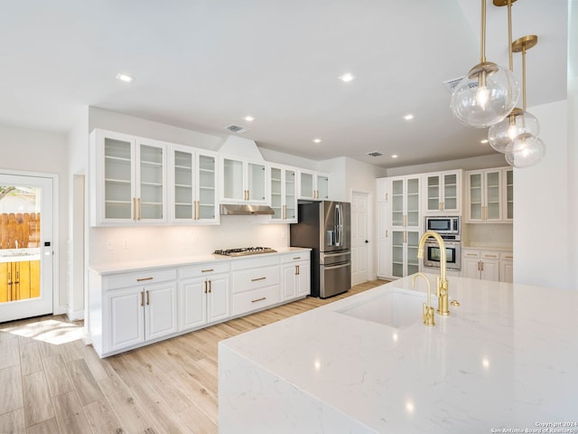 kitchen with sink, white cabinets, light stone countertops, pendant lighting, and appliances with stainless steel finishes