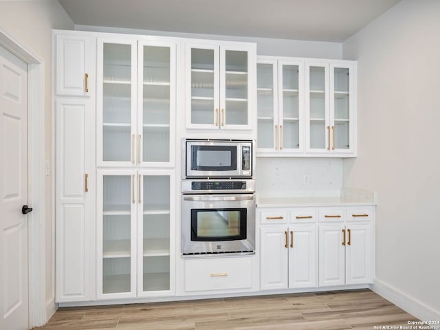 kitchen with light hardwood / wood-style flooring, stainless steel appliances, and white cabinetry