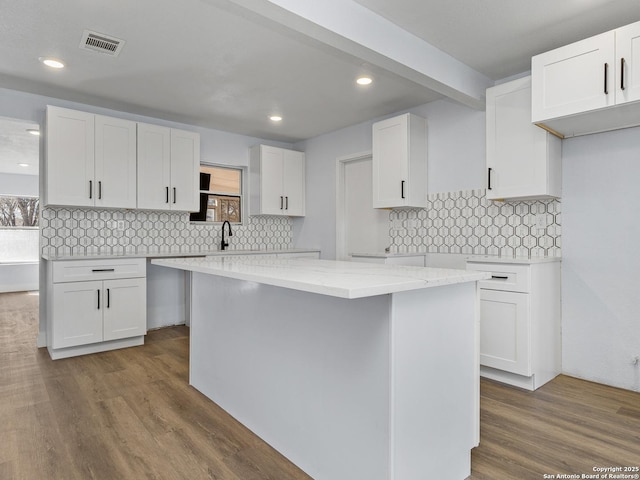 kitchen with sink, white cabinets, and a center island