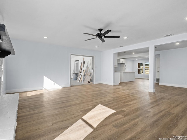 unfurnished living room with wood-type flooring and ceiling fan