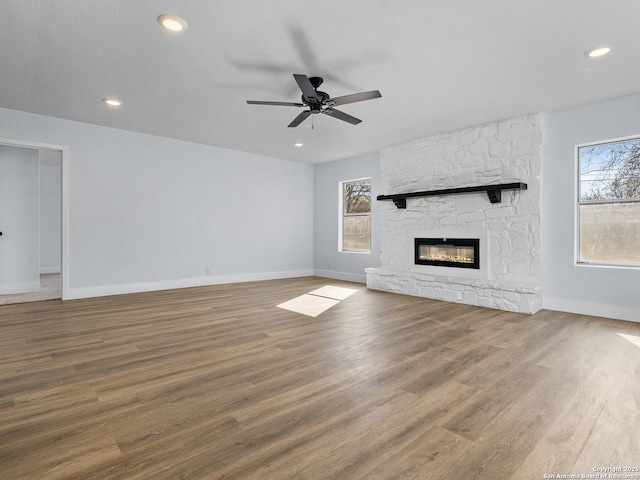 unfurnished living room with ceiling fan, a fireplace, and hardwood / wood-style flooring