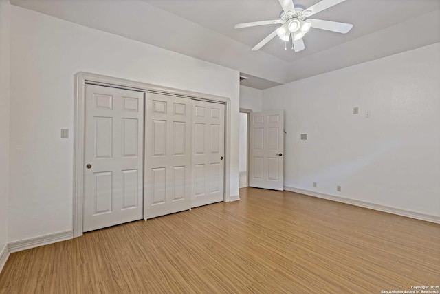 unfurnished bedroom featuring a closet, ceiling fan, and light hardwood / wood-style flooring