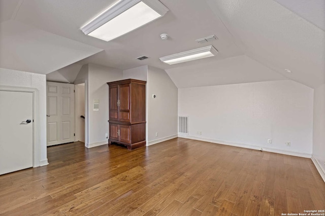 additional living space featuring lofted ceiling and wood-type flooring