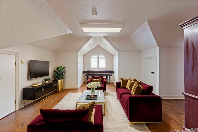 living room featuring lofted ceiling, a textured ceiling, and light wood-type flooring