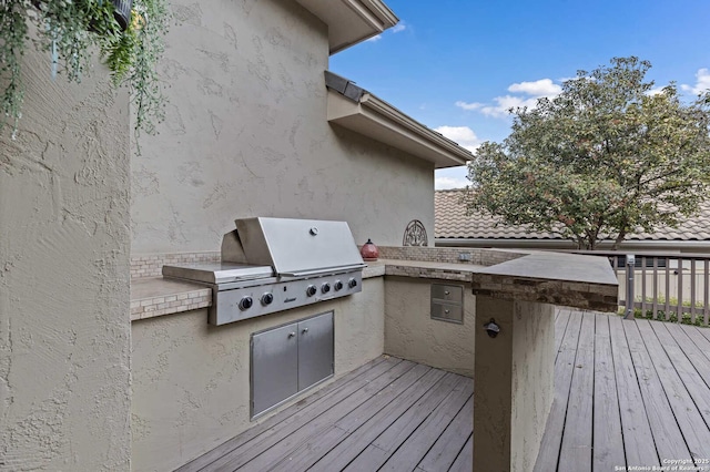 wooden terrace with an outdoor kitchen and area for grilling