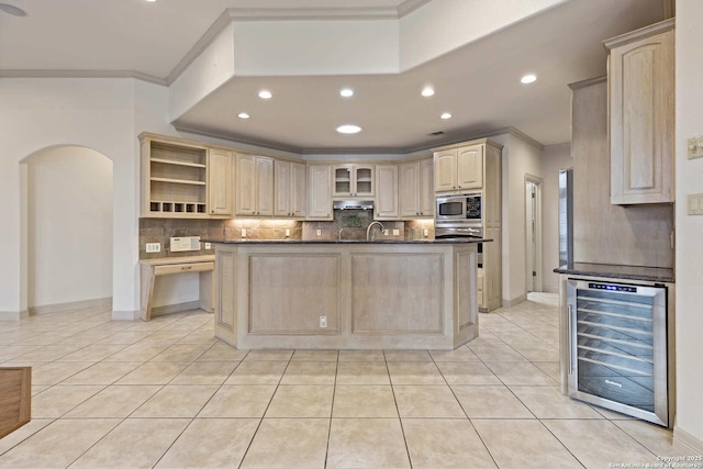 kitchen featuring stainless steel microwave, light tile patterned floors, beverage cooler, backsplash, and crown molding