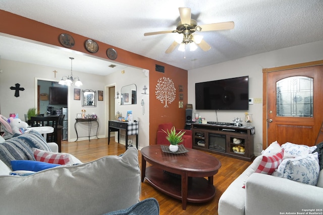 living room with ceiling fan with notable chandelier, a textured ceiling, and hardwood / wood-style floors