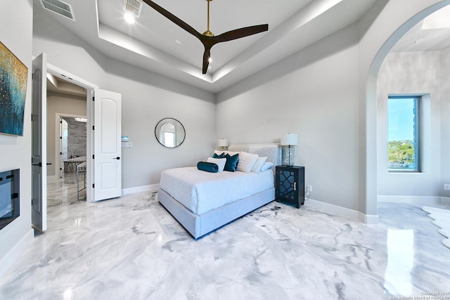 bedroom featuring a raised ceiling and ceiling fan