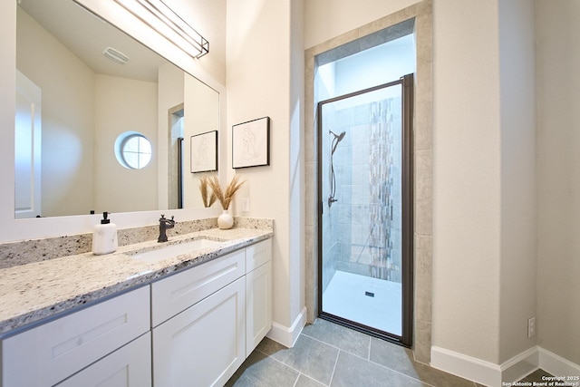 bathroom featuring a shower with door, vanity, and tile patterned floors