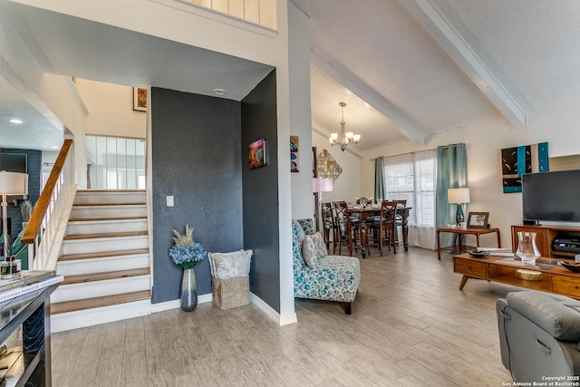 living room featuring an inviting chandelier, beam ceiling, and hardwood / wood-style floors