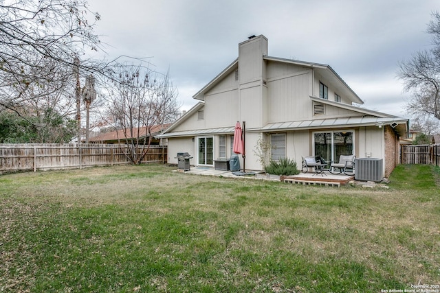 rear view of house featuring a yard, central AC unit, and a wooden deck