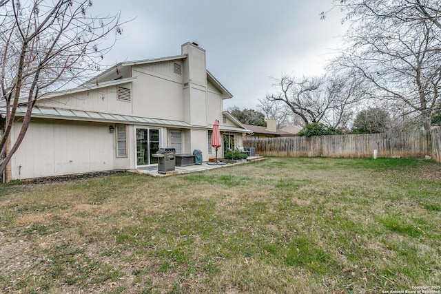 back of property with a yard and a patio area