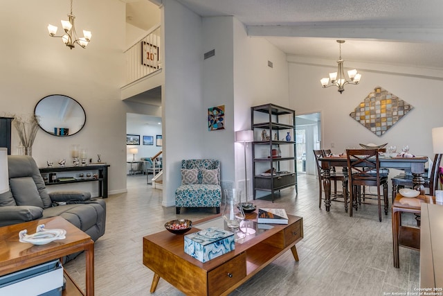 living room featuring a high ceiling, a textured ceiling, beam ceiling, and a notable chandelier