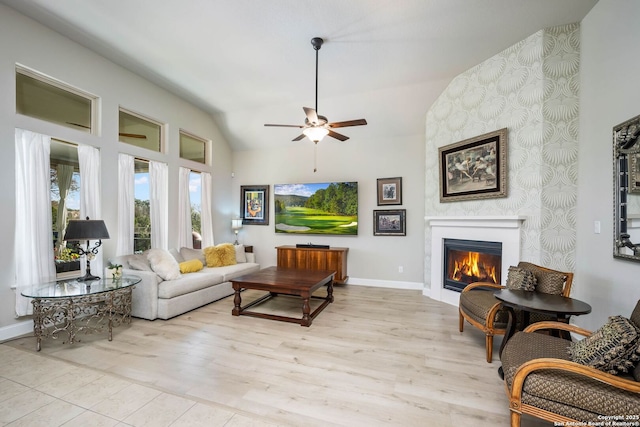 living room with a large fireplace, ceiling fan, and vaulted ceiling