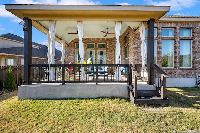 rear view of house with ceiling fan and a yard