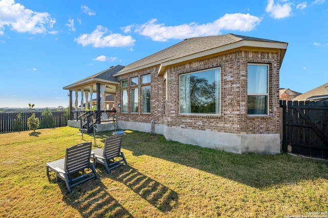 rear view of house with a yard