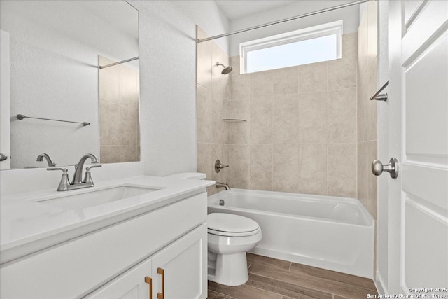 full bathroom with toilet, vanity, and tiled shower / bath combo