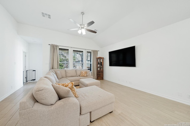 living room featuring vaulted ceiling, ceiling fan, and light hardwood / wood-style flooring