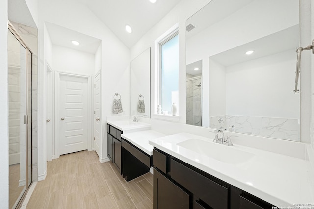 bathroom with lofted ceiling, walk in shower, and vanity