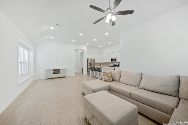 living room featuring sink, ceiling fan, and vaulted ceiling