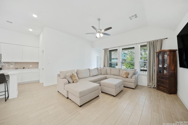 living room featuring lofted ceiling, ceiling fan, and light wood-type flooring