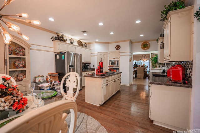 kitchen featuring a kitchen island, appliances with stainless steel finishes, sink, dark hardwood / wood-style flooring, and decorative backsplash