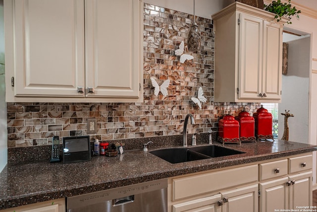 kitchen with dishwasher, sink, decorative backsplash, and dark stone countertops