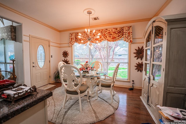 dining space featuring ornamental molding, dark hardwood / wood-style flooring, and a notable chandelier