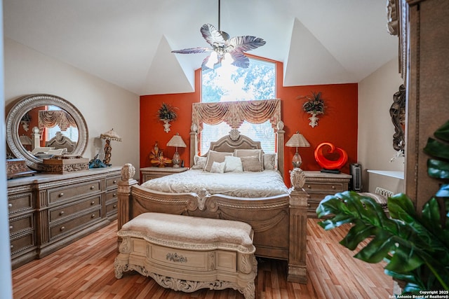 bedroom with lofted ceiling, ceiling fan, and light wood-type flooring