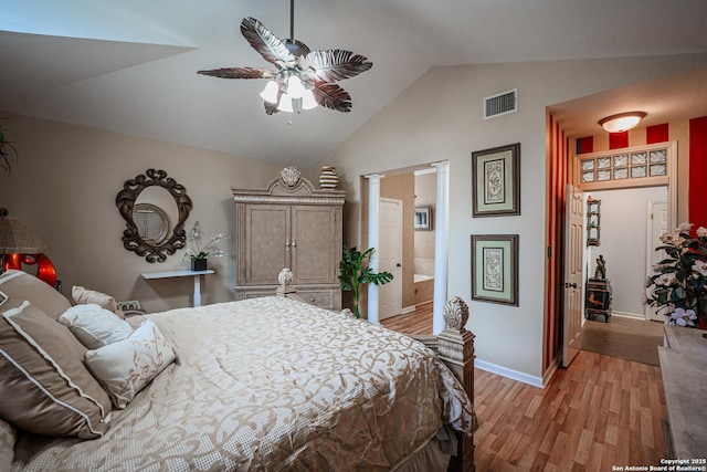 bedroom with lofted ceiling, ensuite bath, ceiling fan, decorative columns, and light hardwood / wood-style floors