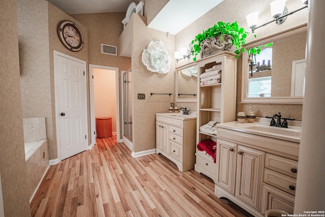 bathroom with vanity, hardwood / wood-style flooring, and shower with separate bathtub