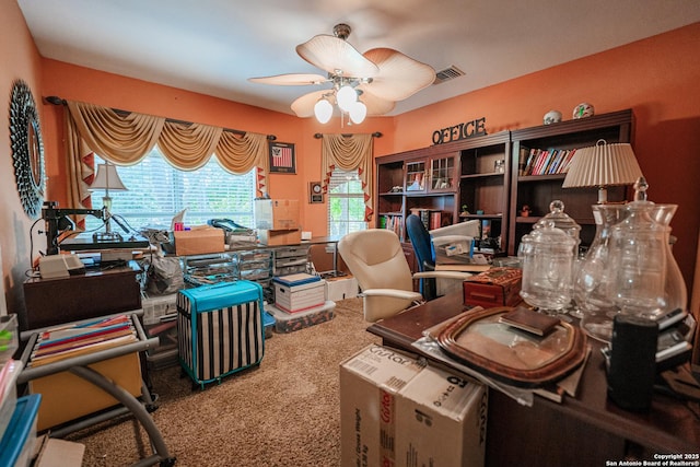 carpeted office space featuring ceiling fan