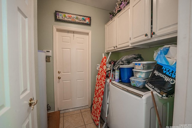 washroom featuring cabinets, washer and clothes dryer, and light tile patterned floors