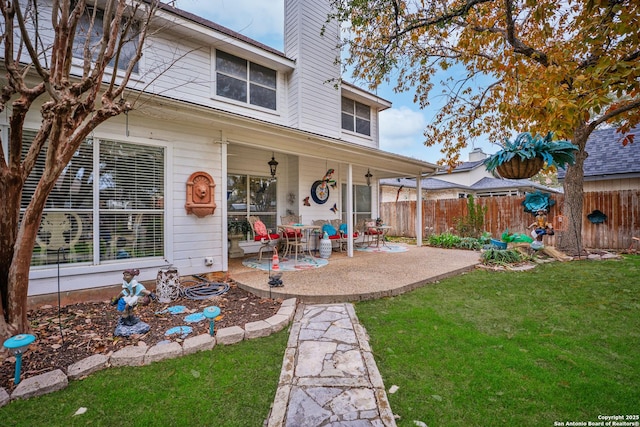 back of house with a patio area and a lawn