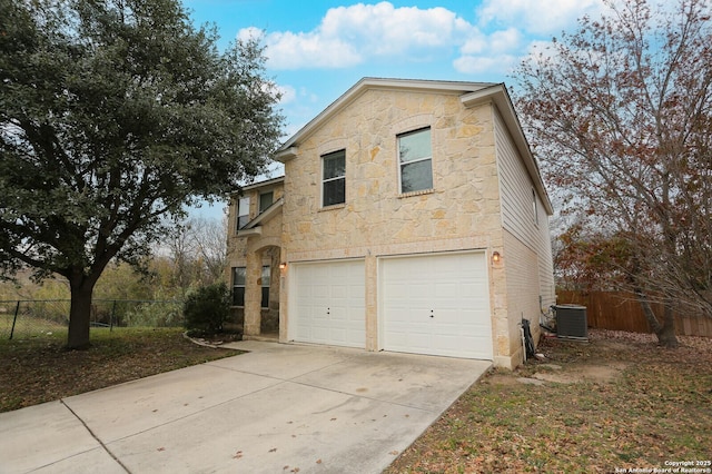 view of front of property featuring central AC unit and a garage