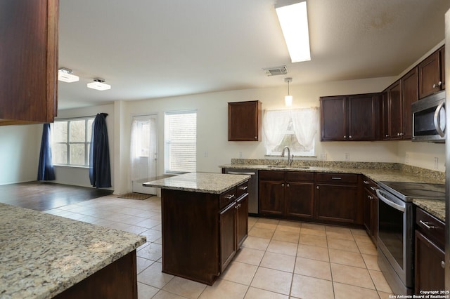 kitchen featuring stainless steel appliances, sink, a center island, light tile patterned flooring, and hanging light fixtures