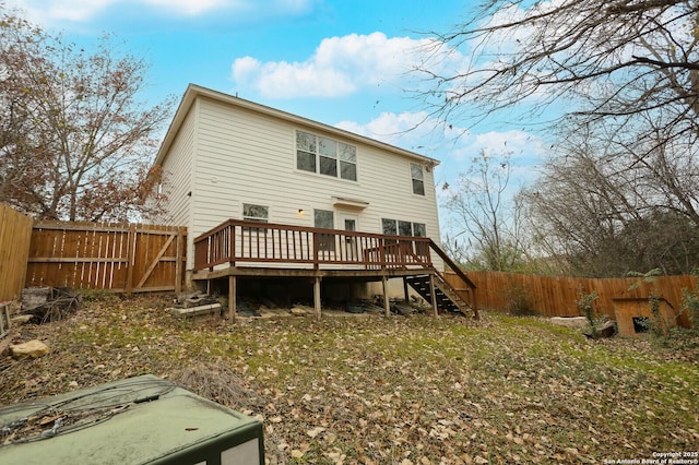 rear view of house with a deck and a yard