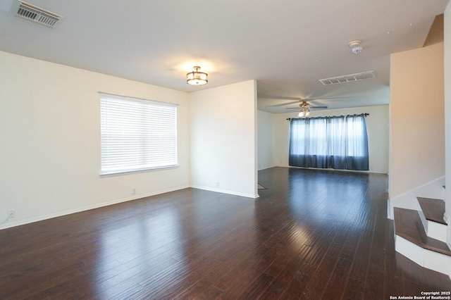 empty room with ceiling fan and dark wood-type flooring