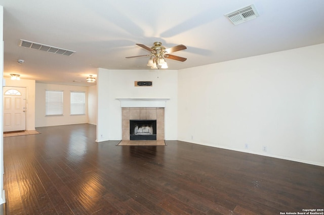 unfurnished living room with a tile fireplace, ceiling fan, and dark hardwood / wood-style floors