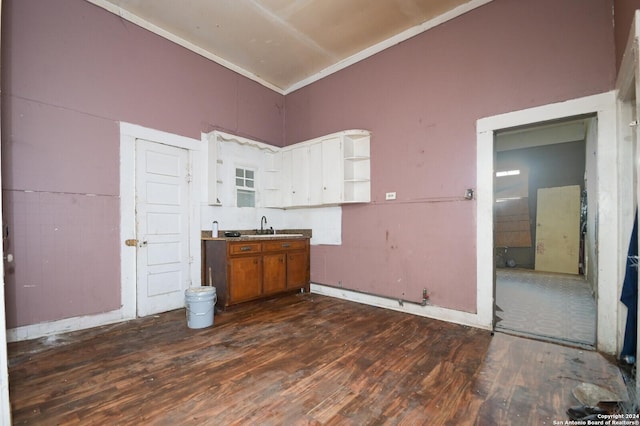 kitchen featuring white cabinets, dark hardwood / wood-style flooring, a towering ceiling, and sink