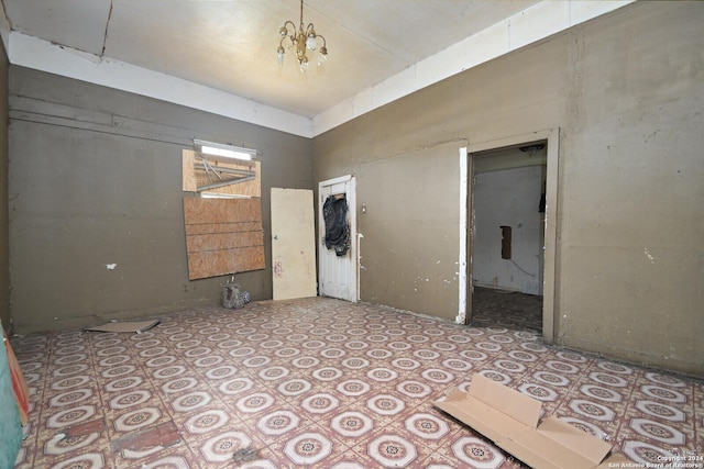 unfurnished room featuring a chandelier