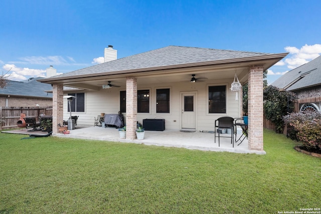 rear view of property featuring ceiling fan, a yard, and a patio