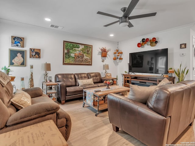 living room with ceiling fan, light wood-type flooring, and crown molding