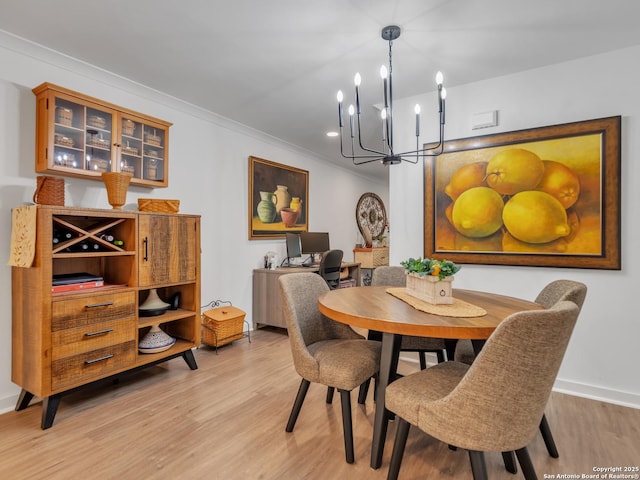 dining area with a chandelier, crown molding, and light hardwood / wood-style floors