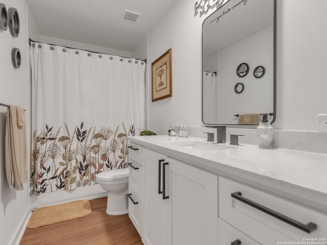 bathroom with toilet, vanity, a shower with curtain, and hardwood / wood-style floors