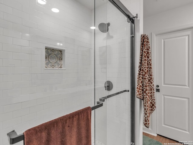 bathroom featuring an enclosed shower and hardwood / wood-style flooring